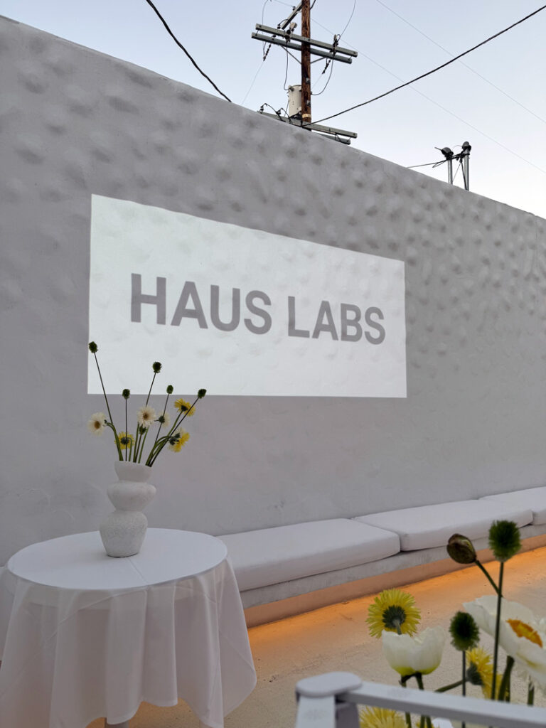 Haus Labs logo projected on the side of a textured wall