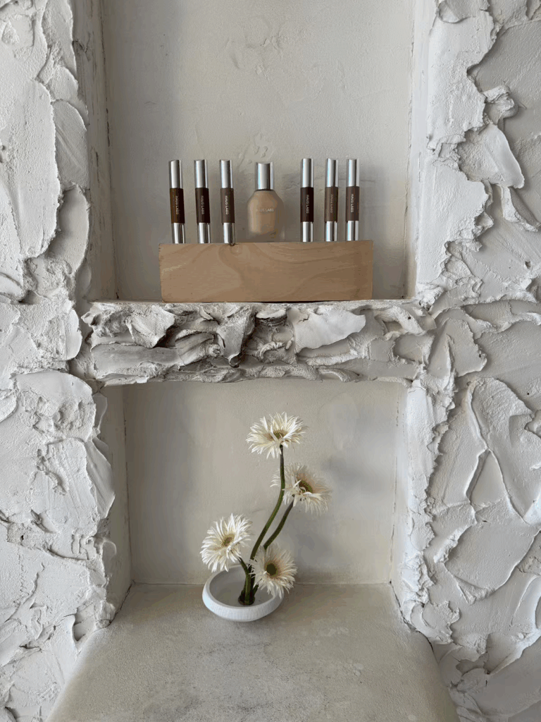 Haus Labs make up neatly displayed in a textured wall