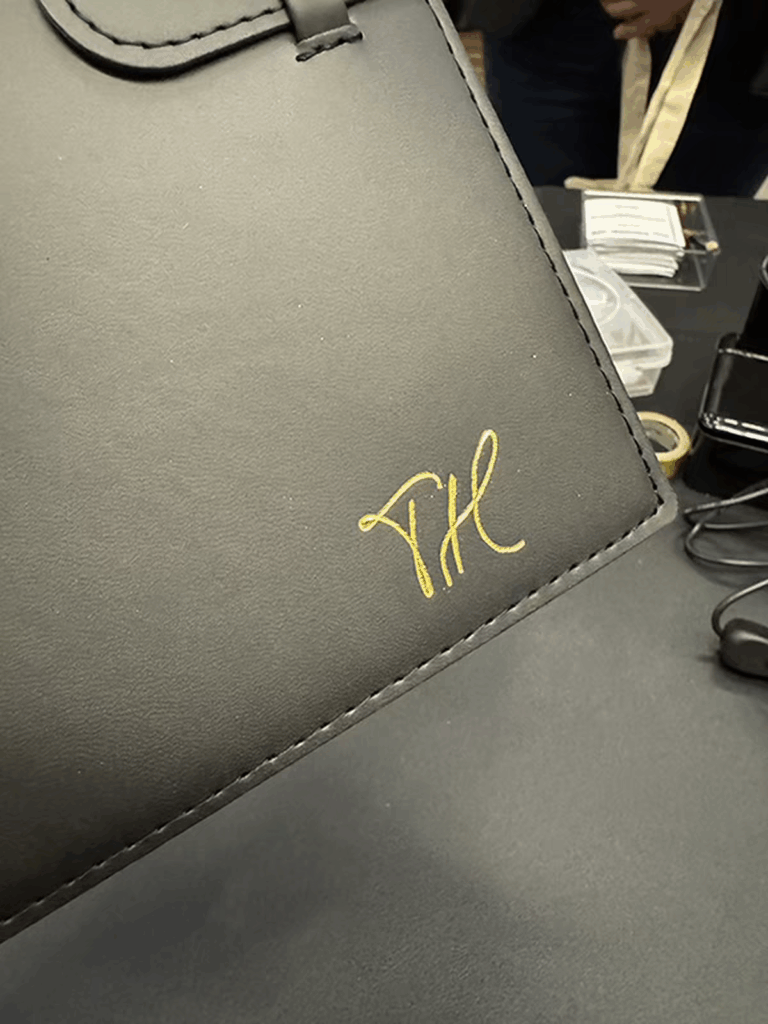 The initials "TH" in gold foil on a black journal