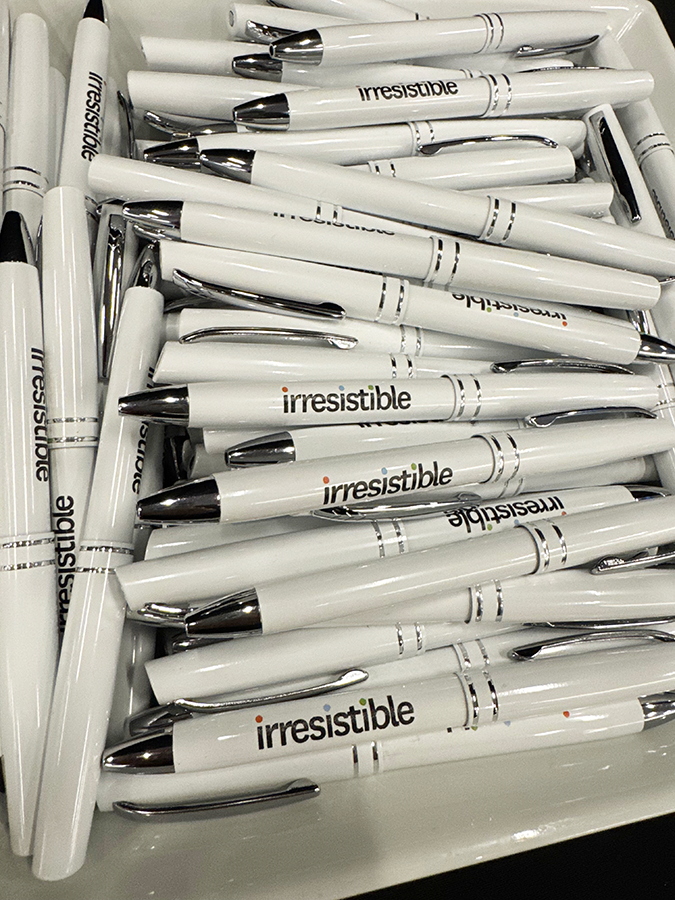 Bin filled with white Irrestistible logo pens