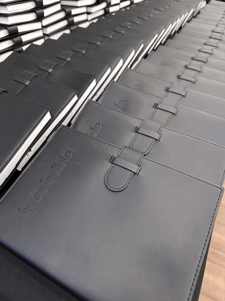 Black refillable journals with the Irresistible logo debossed on the cover