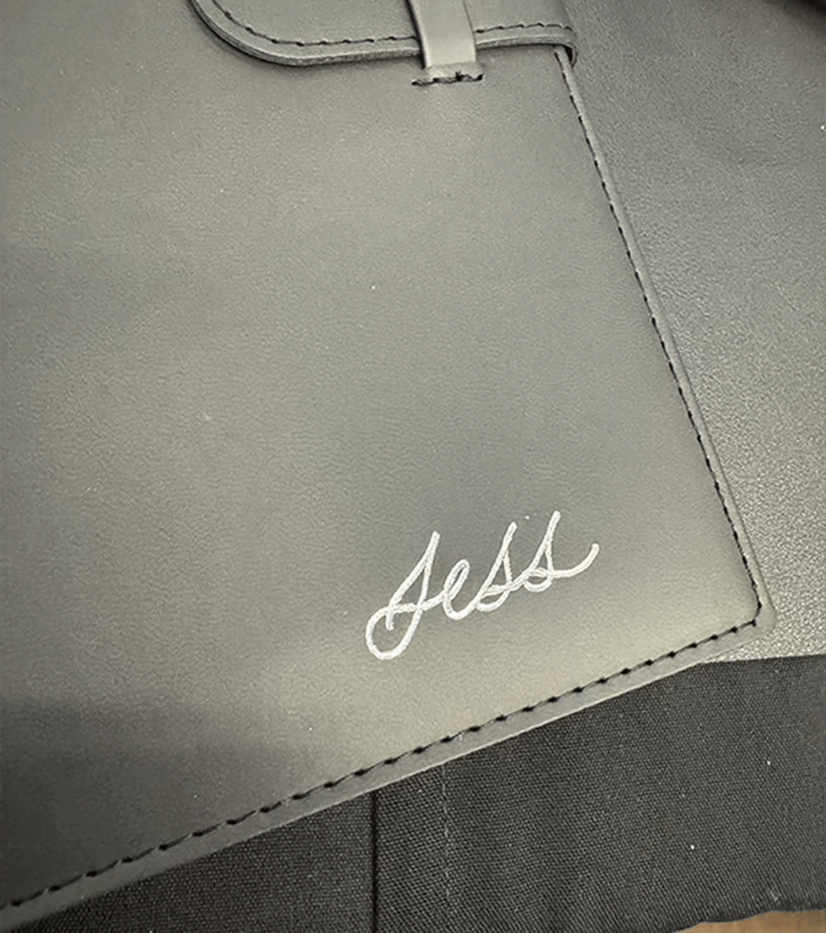 Silver hot foil calligraphy on a black journal with the name Jess