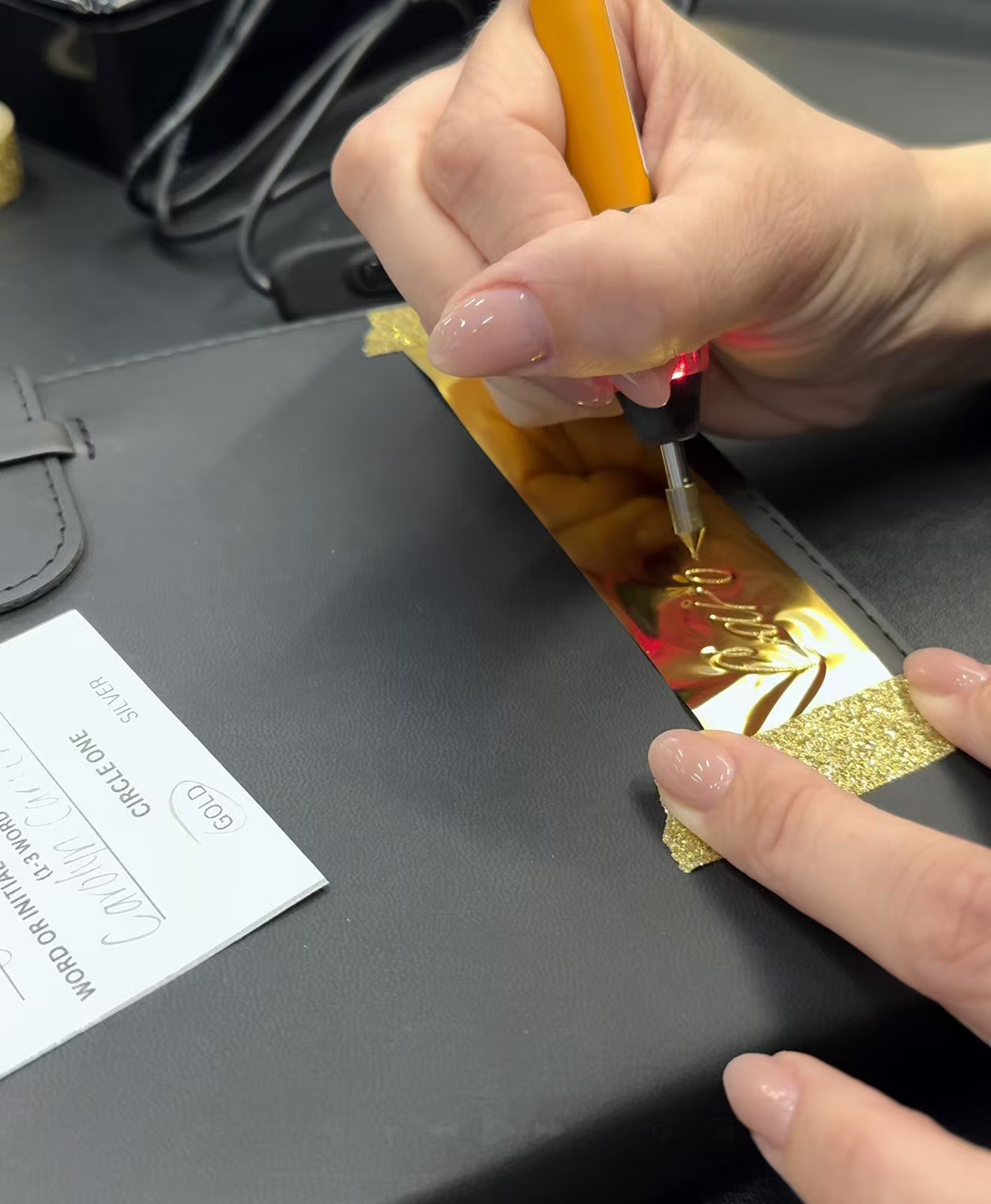 Calligrapher Hot Foiling a Journal for a guest with their name in gold