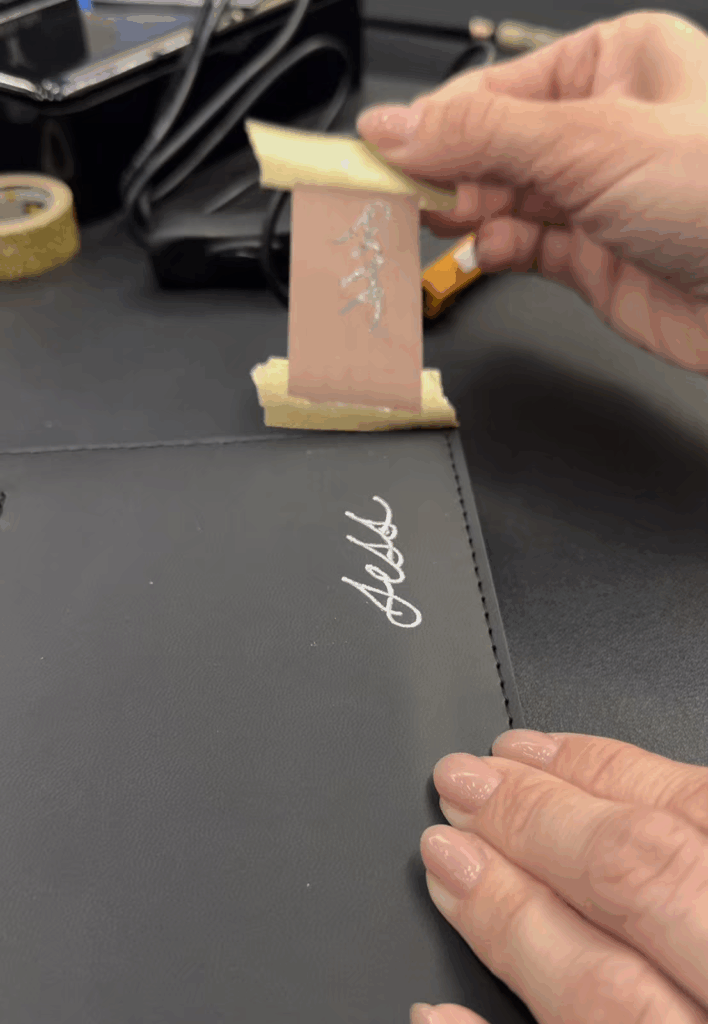 Peeling of silver hot foil calligraphy on a black journal