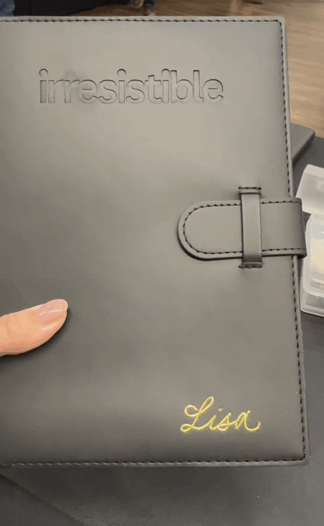 The name Lisa calligraphed in gold foil on a black journal