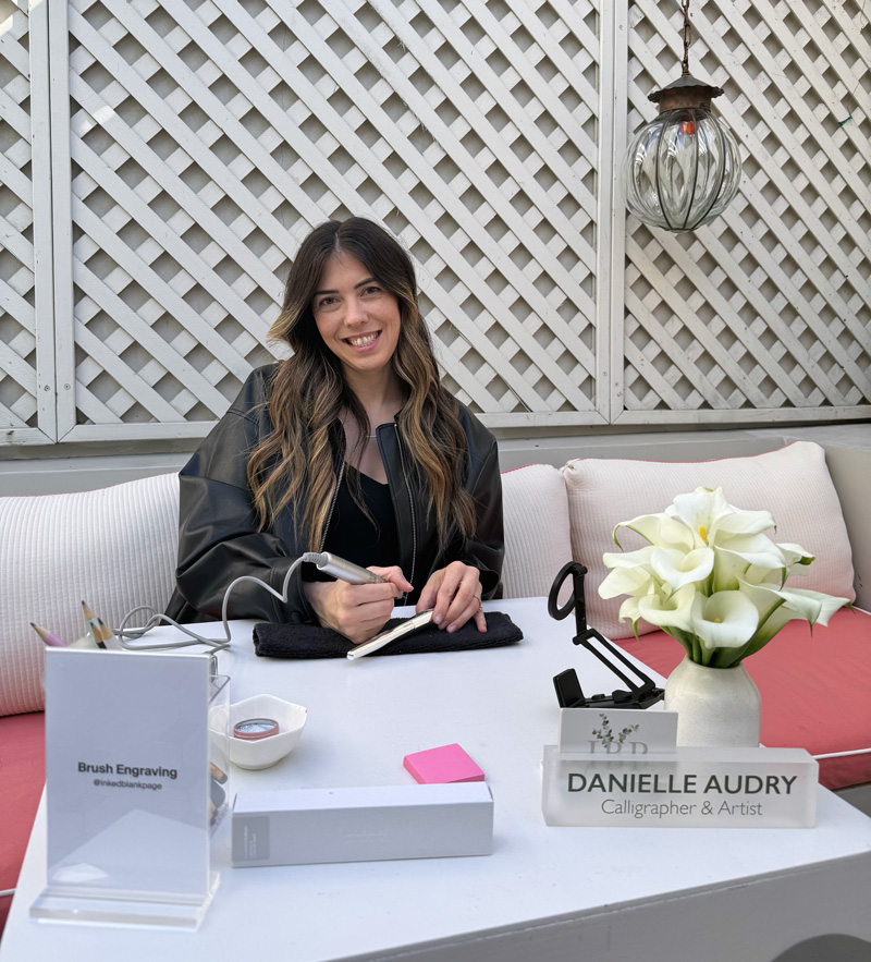 Calligraphy Hand Engraving artist performing her engraving services at an event with Beauty Brand Haus Labs